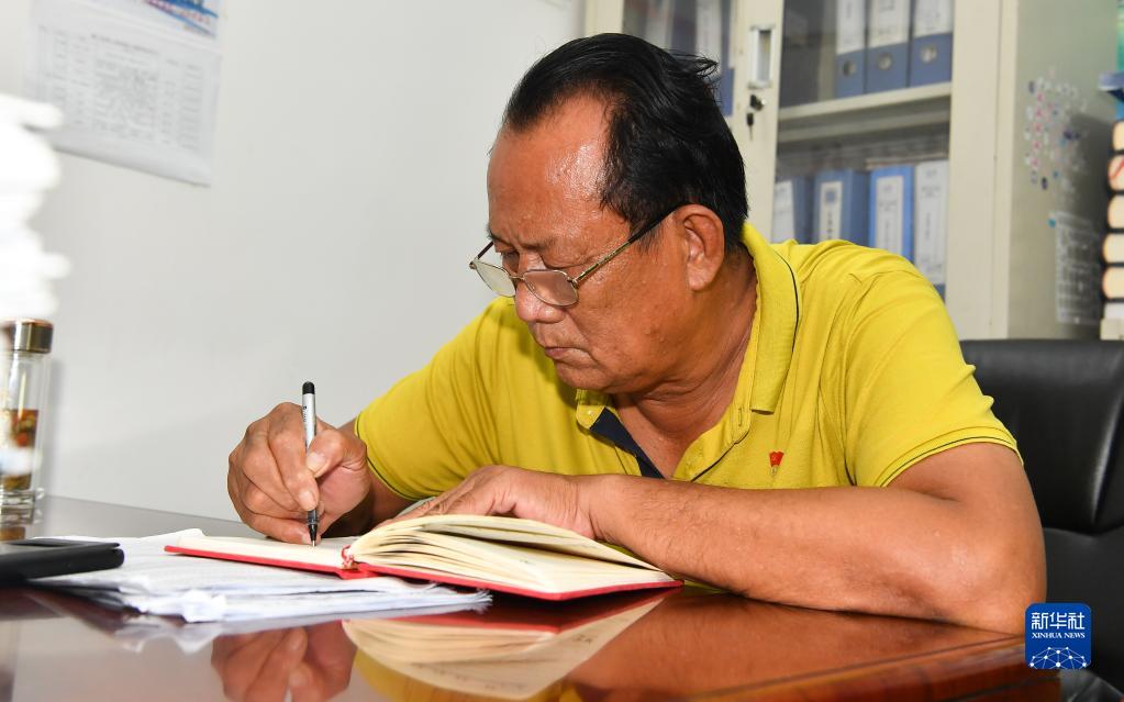 王书茂在海南省琼海市潭门镇潭门村村委会办公室工作（9月14日摄）。
